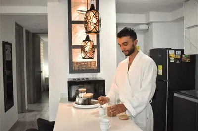 a man in a bathrobe standing in a kitchen at Lindo y disponible Apartamento camino a termales in Manizales