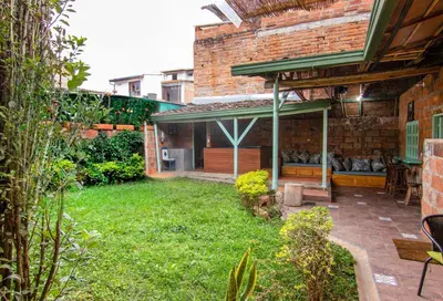 a backyard with a brick building and a green yard at CASA DUQUE JARDIN in Jardin