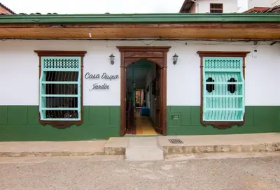 a green and white building with a door and windows at CASA DUQUE JARDIN in Jardin