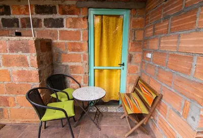 a patio with a table and chairs and a window at CASA DUQUE JARDIN in Jardin