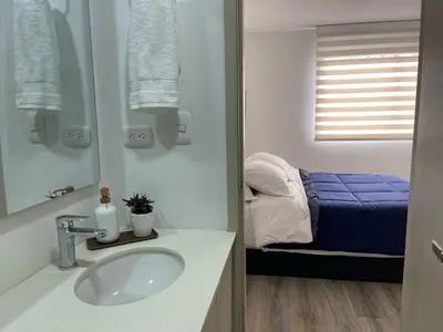 a bathroom with a sink and a bed at Apartamento frente a Mallplaza in Manizales