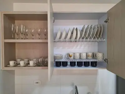 a cupboard filled with plates and glasses and bowls at Apartamento frente a Mallplaza in Manizales