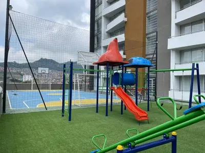a playground with a slide and a swing at Apartamento frente a Mallplaza in Manizales