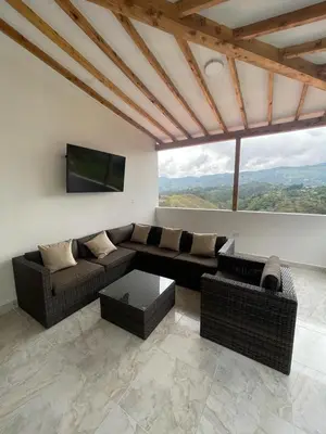 a living room with a couch and a flat screen tv at Cómoda casa con espectacular vista a la piedra y embalse in Guatapé