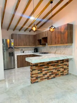 a large kitchen with wooden cabinets and a counter top at Cómoda casa con espectacular vista a la piedra y embalse in Guatapé