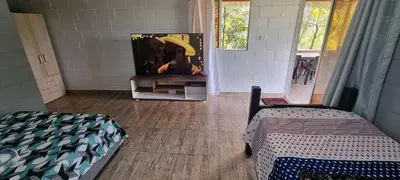 a room with a tv on a stand with a bed at Cabaña rodeada de naturaleza in Cocorná