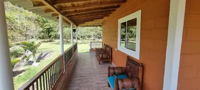 a porch of a house with chairs on it at Cabaña rodeada de naturaleza in Cocorná