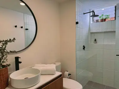 a bathroom with a sink and a shower with a mirror at Seijakumanila in Medellín