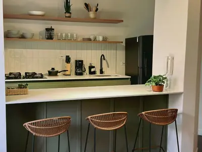a kitchen with a counter and three stools at Seijakumanila in Medellín