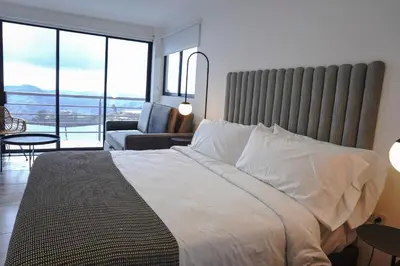 a bedroom with a large bed and a living room at Hotel Villa Del Sol in Marquetalia