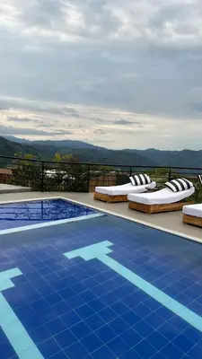a swimming pool with chaise lounge chairs next to at Hotel Villa Del Sol in Marquetalia