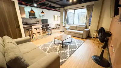 a living room with a couch and a kitchen at Apartamentos en el Poblado Medellín - Be Together by Roots Rentals TOG APTOS in Medellín