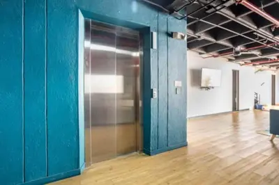 an empty room with a blue wall and a wooden floor at Apartamentos en el Poblado Medellín - Be Together by Roots Rentals TOG APTOS in Medellín
