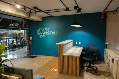 an office with a blue wall and a desk and chairs at Apartamentos en el Poblado Medellín - Be Together by Roots Rentals TOG APTOS in Medellín