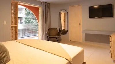 a bedroom with a bed and a chair and a window at Leviu by Bernalo Hotels in Medellín