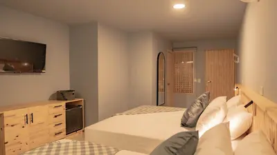 a bedroom with two beds and a flat screen tv at Leviu by Bernalo Hotels in Medellín
