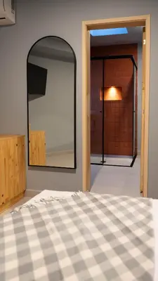 a bedroom with a large mirror on the wall at Leviu by Bernalo Hotels in Medellín