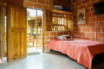 a bedroom with a bed and a brick wall at Hotel Campestre - CIUDADELA EL ARTESANO in Carolina del Principe