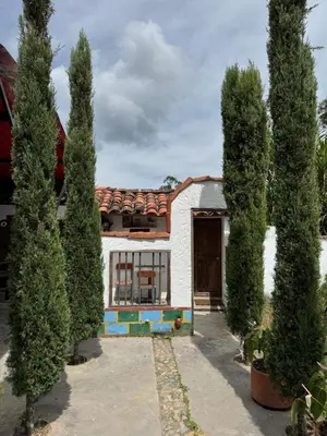 a group of trees in front of a house at Hotel Campestre - CIUDADELA EL ARTESANO in Carolina del Principe