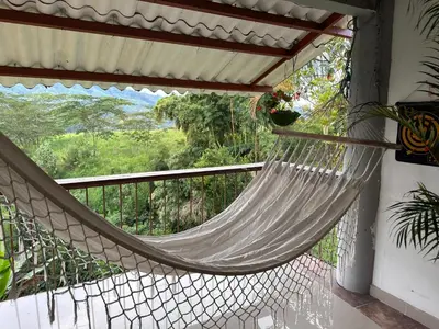 a hammock on the balcony of a house at El Refugio del Colibrí in Santa Rosa de Cabal