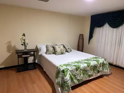 a bedroom with a bed and a table and a window at El Refugio del Colibrí in Santa Rosa de Cabal