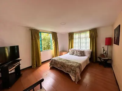 a bedroom with a bed and a large window at El Refugio del Colibrí in Santa Rosa de Cabal