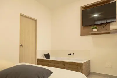 a bedroom with a bath tub and a television on the wall at Loma Rent Home Guatape in Guatapé