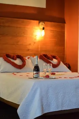 a table with a bottle of wine and two glasses at Hotel Casita de Belén in Sonsón