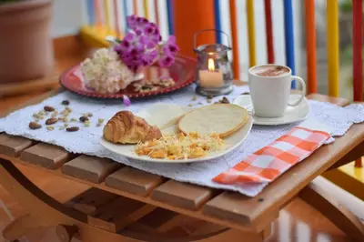 a table with a plate of food and a cup of coffee at Hotel Casita de Belén in Sonsón