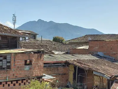 a group of brick buildings with mountains in the background at Hotel Casita de Belén in Sonsón