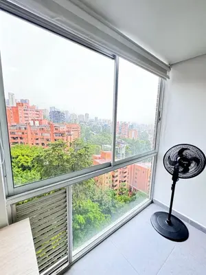 a room with a large window with a fan at 1705 Beautiful apartament, total view of the city in Medellín