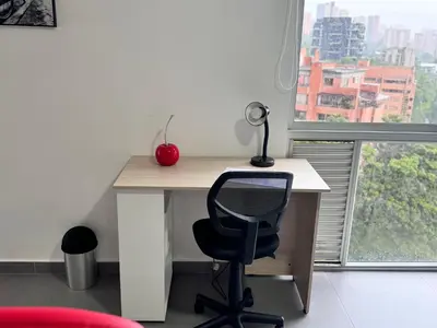 a desk with a chair and a red apple on it at 1705 Beautiful apartament, total view of the city in Medellín