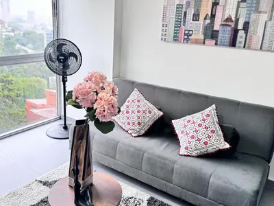 a living room with a gray couch with flowers in a vase at 1705 Beautiful apartament, total view of the city in Medellín