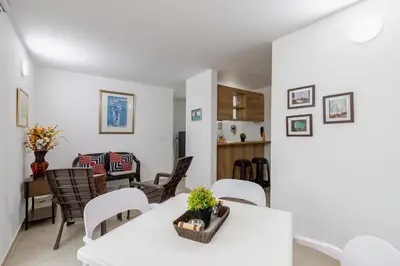 a dining room and living room with white tables and chairs at Full Apartamento Privado 202 Guatapé in Guatapé