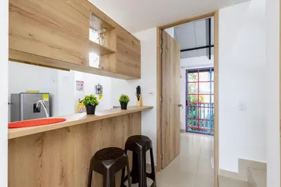 a kitchen with two black stools in front of a counter at Full Apartamento Privado 202 Guatapé in Guatapé