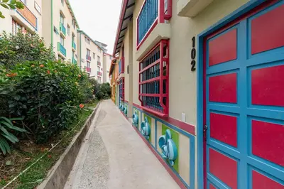 an alley with a blue and red door on a building at Full Apartamento Privado 202 Guatapé in Guatapé