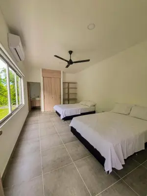 a bedroom with two beds and a ceiling fan at Finca Luz de Luna in Santa Fe de Antioquia