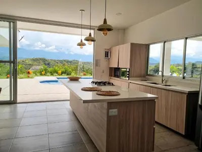 a kitchen with a counter with a view of a pool at Finca Luz de Luna in Santa Fe de Antioquia