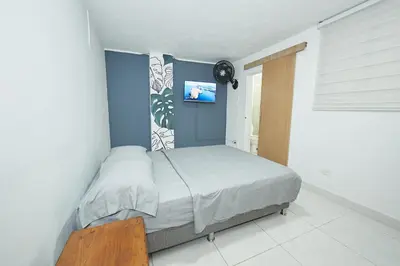 a bedroom with a bed and a tv on the wall at Hostal Casa Host 72 in Medellín