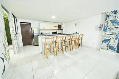 a kitchen with wooden stools and a counter top at Hostal Casa Host 72 in Medellín
