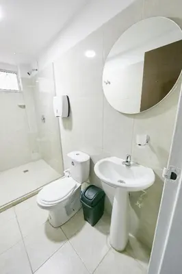 a bathroom with a toilet and a sink and a mirror at Hostal Casa Host 72 in Medellín