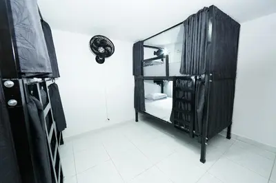 a bathroom with a mirror and a black cabinet at Hostal Casa Host 72 in Medellín