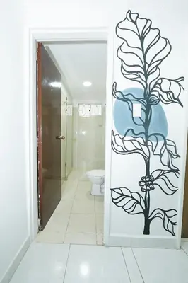 a bathroom with a door with a plant painted on it at Hostal Casa Host 72 in Medellín