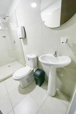 a bathroom with a toilet and a sink and a mirror at Hostal Casa Host 72 in Medellín