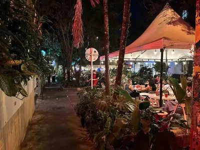 a restaurant with people sitting at tables at night at POBLADO PARK MANILA in Medellín