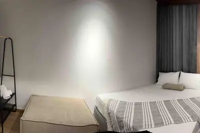 a small bedroom with a bed and a mirror at POBLADO PARK MANILA in Medellín