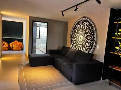 a living room with a couch and a large picture on the wall at POBLADO PARK LUXURY APARTMENT's in Medellín