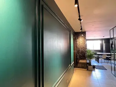 a hallway with a green wall and a table at POBLADO PARK LUXURY APARTMENT's in Medellín