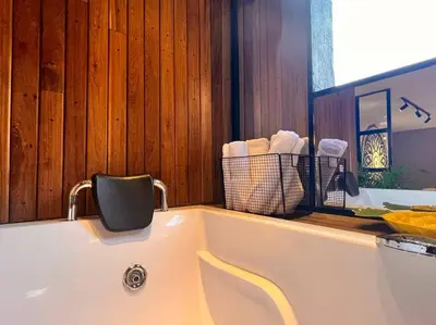 a bath tub with a chair in a bathroom at POBLADO PARK LUXURY APARTMENT's in Medellín