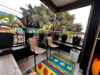 a balcony with two chairs and a table and a rug at POBLADO PARK LUXURY APARTMENT's in Medellín